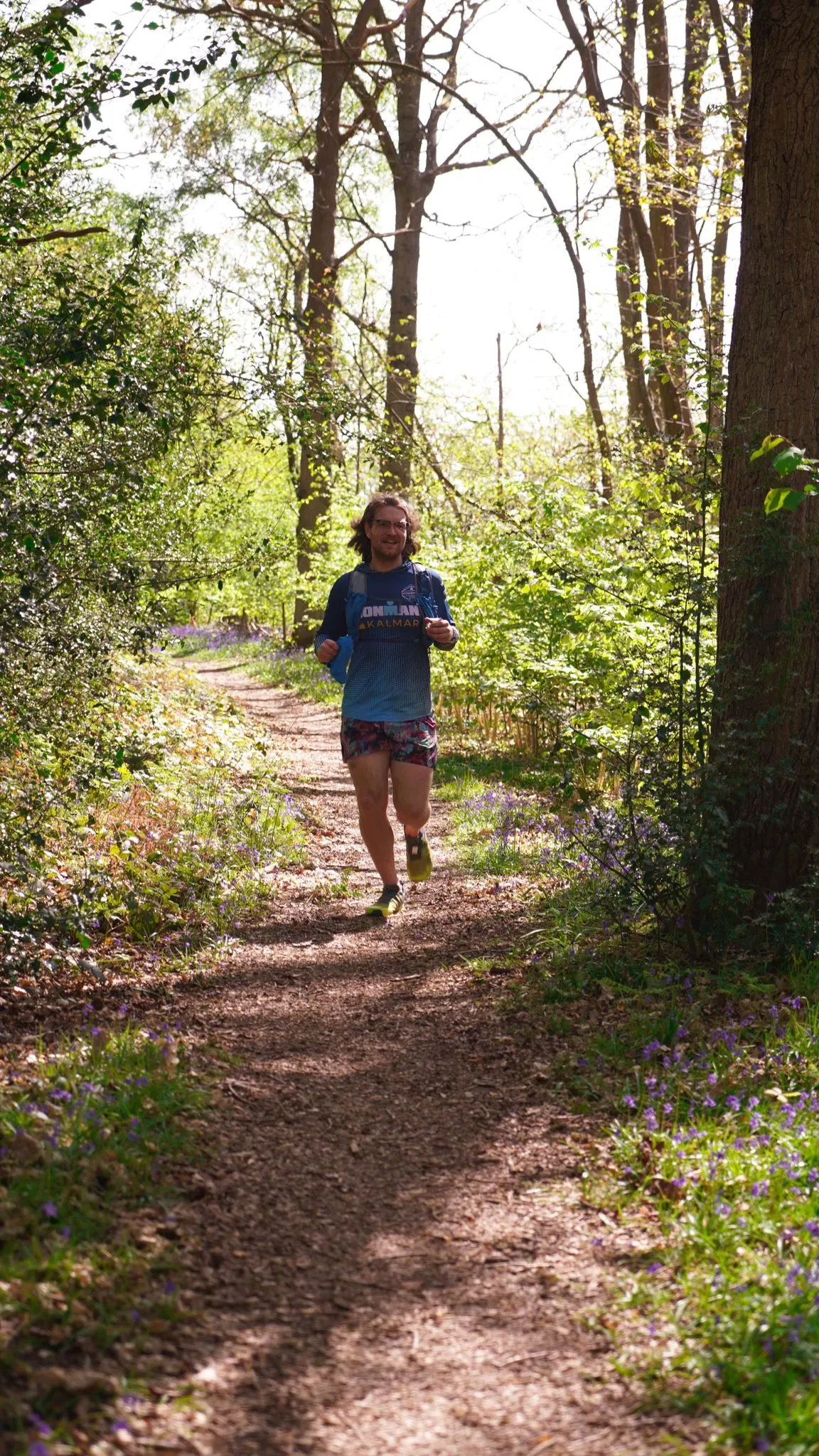 A runner smiling on the bluebell woodland trail at last year's race